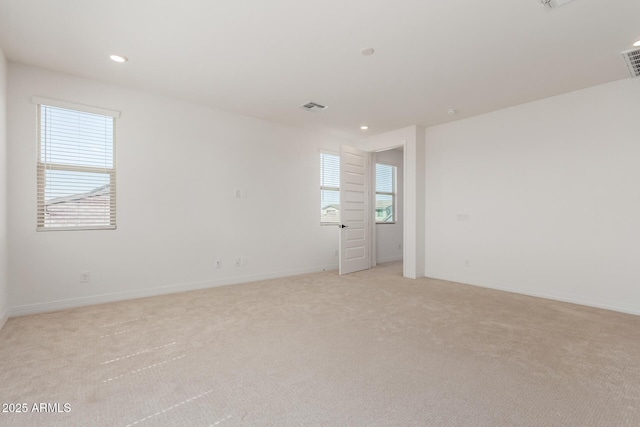 empty room with light carpet, visible vents, recessed lighting, and baseboards