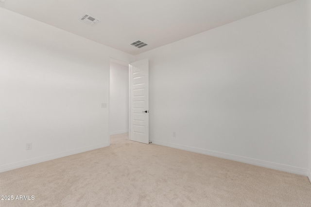 spare room with visible vents, light carpet, and baseboards