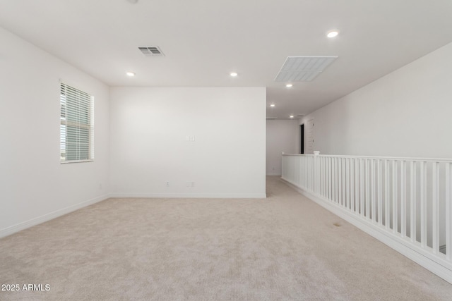 empty room featuring recessed lighting, visible vents, light colored carpet, and baseboards