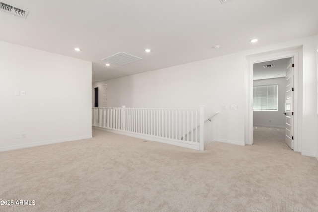 empty room featuring light colored carpet, recessed lighting, visible vents, and baseboards