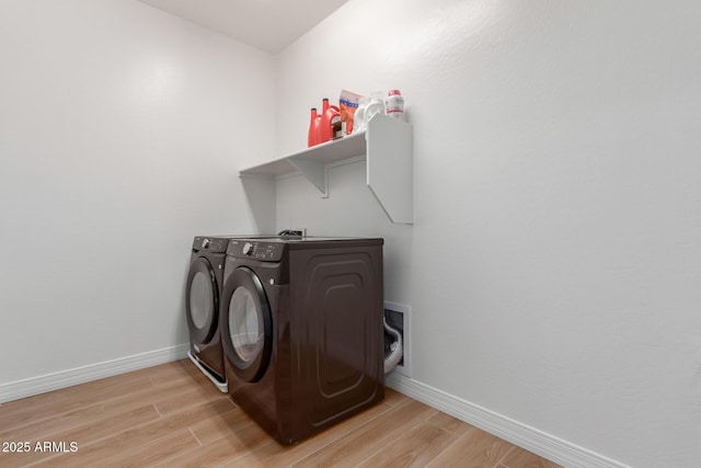 clothes washing area with laundry area, baseboards, independent washer and dryer, and light wood-type flooring