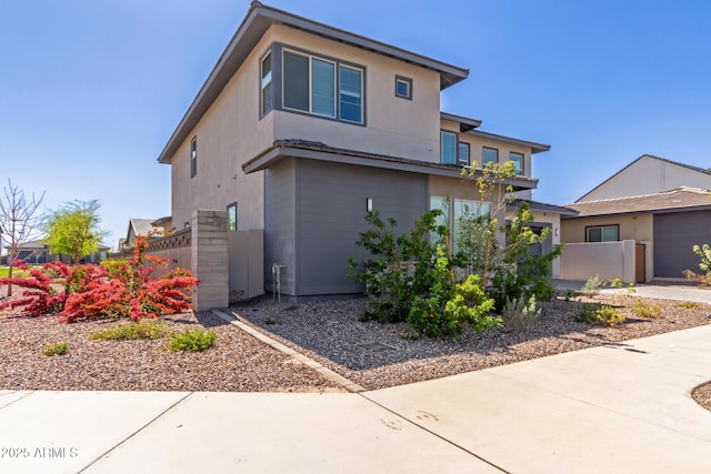 exterior space featuring a gate, stucco siding, and fence