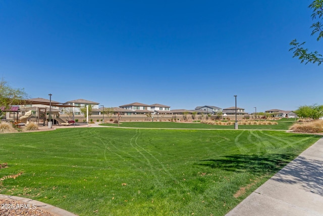 view of community featuring playground community and a lawn