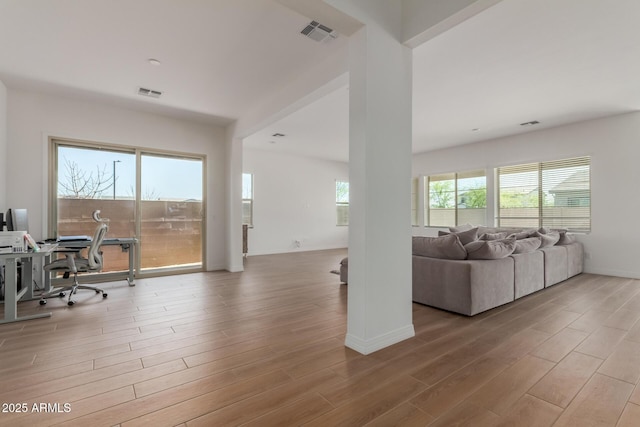 living area featuring wood finished floors, visible vents, and baseboards