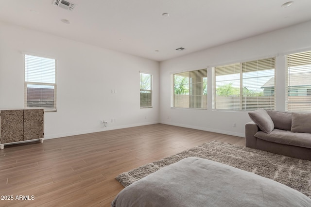 bedroom featuring light wood-type flooring, visible vents, and baseboards