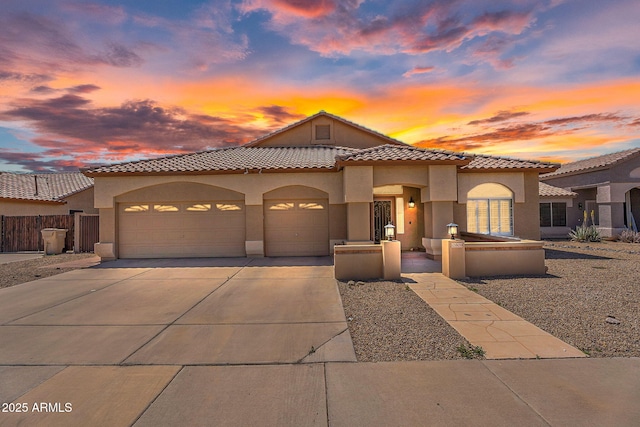 10809 W Harmony Ln, Peoria, AZ 85373 - mediterranean / spanish house featuring stucco siding, fence, a garage, a tile roof, and concrete driveway