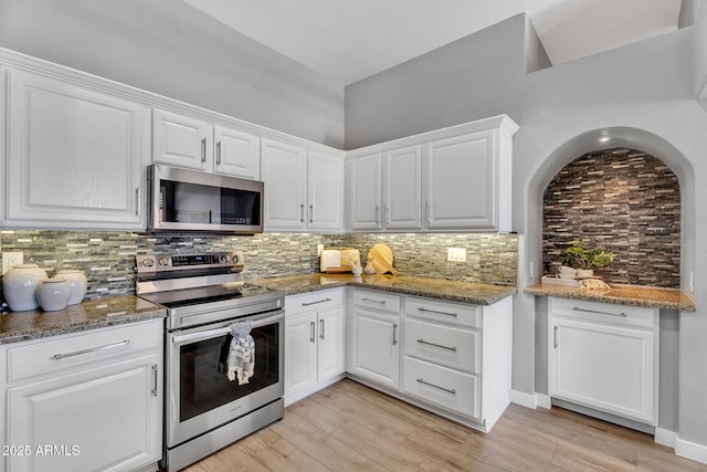 10809 W Harmony Ln, Peoria, AZ 85373 - kitchen featuring light wood finished floors, white cabinets, stainless steel appliances, and tasteful backsplash