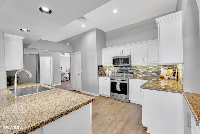 10809 W Harmony Ln, Peoria, AZ 85373 - kitchen featuring a sink, stainless steel appliances, light wood-style floors, visible vents, and white cabinetry