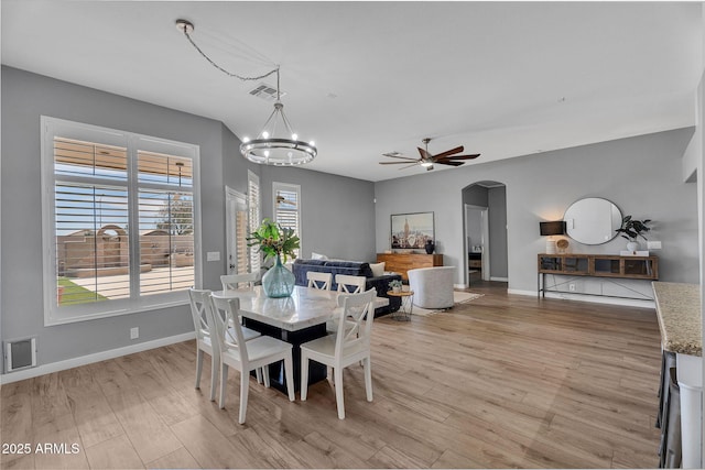 10809 W Harmony Ln, Peoria, AZ 85373 - dining room featuring baseboards, visible vents, arched walkways, and light wood-type flooring