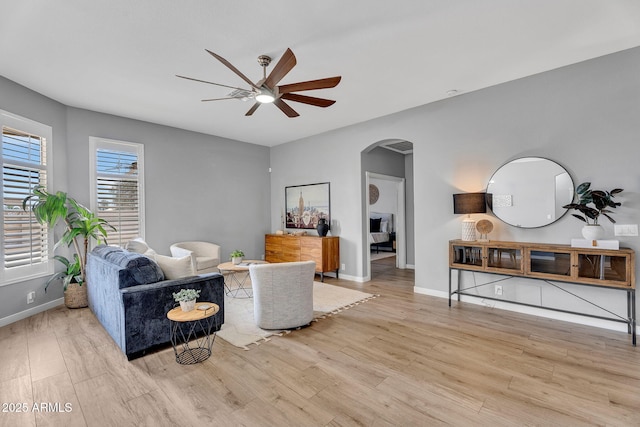 10809 W Harmony Ln, Peoria, AZ 85373 - living room featuring a ceiling fan, arched walkways, and wood finished floors
