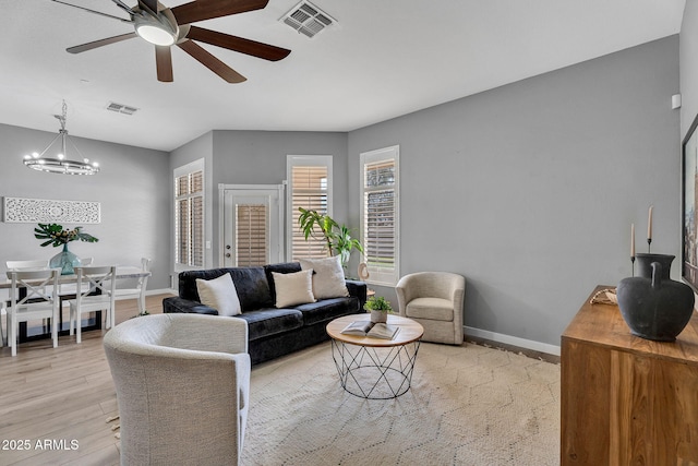 10809 W Harmony Ln, Peoria, AZ 85373 - living area featuring visible vents, baseboards, light wood-style flooring, and ceiling fan with notable chandelier