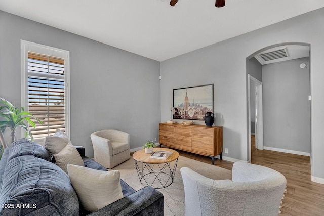 10809 W Harmony Ln, Peoria, AZ 85373 - living area with arched walkways, light wood-style floors, ceiling fan, baseboards, and visible vents