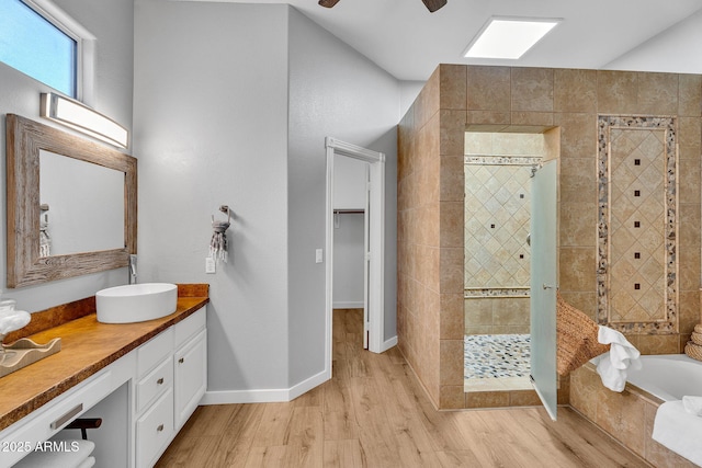 10809 W Harmony Ln, Peoria, AZ 85373 - full bath featuring a shower stall, vanity, baseboards, a garden tub, and wood finished floors