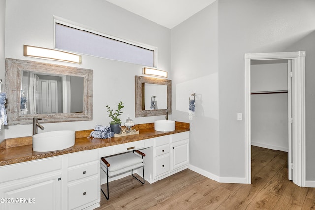 10809 W Harmony Ln, Peoria, AZ 85373 - bathroom with a walk in closet, double vanity, a sink, and wood finished floors