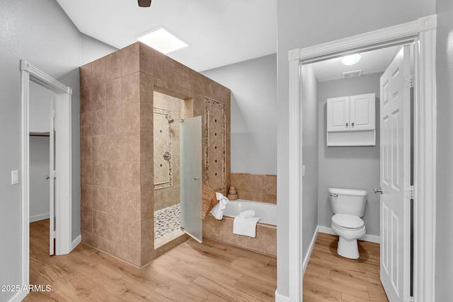10809 W Harmony Ln, Peoria, AZ 85373 - bathroom with a stall shower, wood finished floors, and a bath
