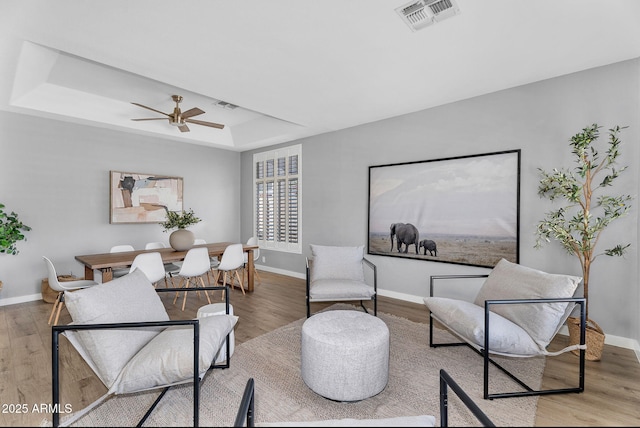 10809 W Harmony Ln, Peoria, AZ 85373 - living area with visible vents, wood finished floors, a raised ceiling, and baseboards