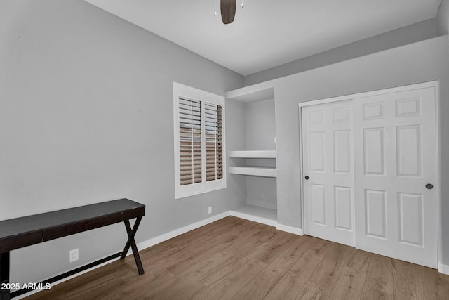 10809 W Harmony Ln, Peoria, AZ 85373 - unfurnished bedroom with baseboards, wood finished floors, a ceiling fan, and a closet