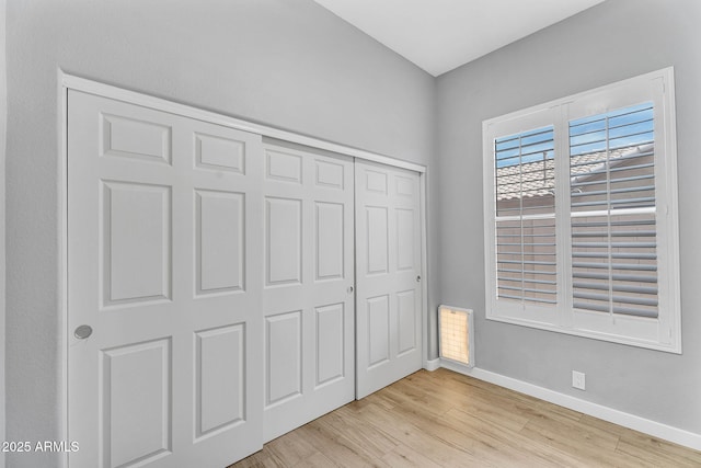 10809 W Harmony Ln, Peoria, AZ 85373 - unfurnished bedroom with baseboards, a closet, and light wood-style flooring