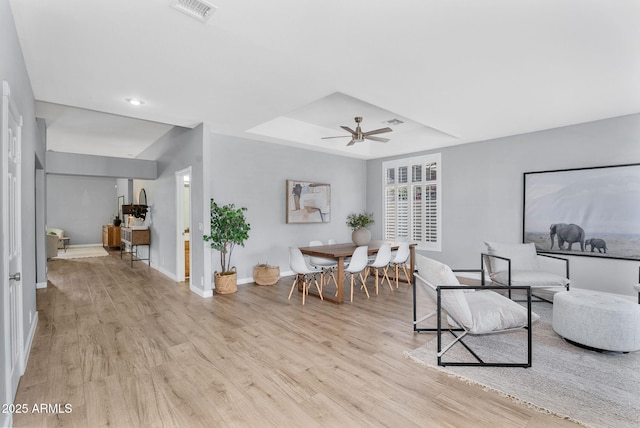 10809 W Harmony Ln, Peoria, AZ 85373 - living area featuring a raised ceiling, visible vents, baseboards, light wood finished floors, and a ceiling fan