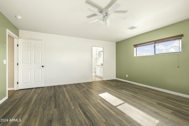 unfurnished bedroom with ceiling fan, dark wood-type flooring, and ensuite bath