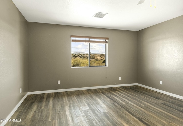 unfurnished room featuring ceiling fan and dark hardwood / wood-style flooring