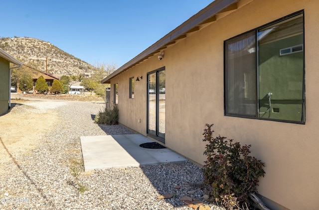 view of side of property featuring a mountain view and a patio