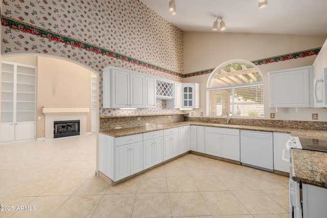 728 W Sandra Ter, Phoenix, AZ 85023 - kitchen with white appliances, light tile patterned flooring, high vaulted ceiling, white cabinets, and a fireplace