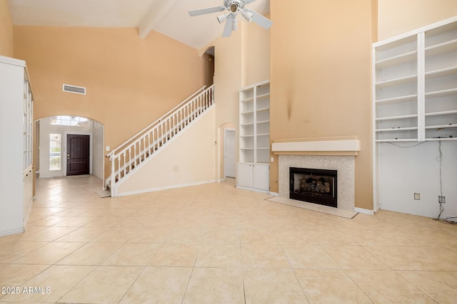728 W Sandra Ter, Phoenix, AZ 85023 - unfurnished living room featuring arched walkways, a ceiling fan, tile patterned floors, beamed ceiling, and stairway
