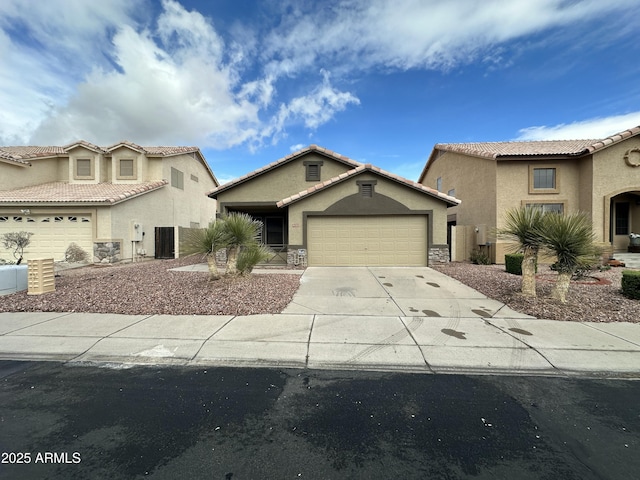 mediterranean / spanish home featuring a garage, stone siding, concrete driveway, and stucco siding