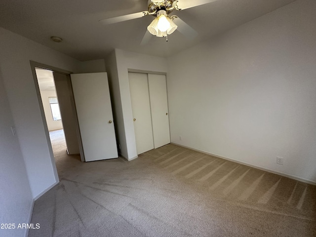 unfurnished bedroom with a ceiling fan, carpet, and a closet