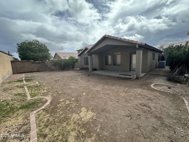 exterior space featuring a tile roof, a patio, stucco siding, central AC, and a fenced backyard