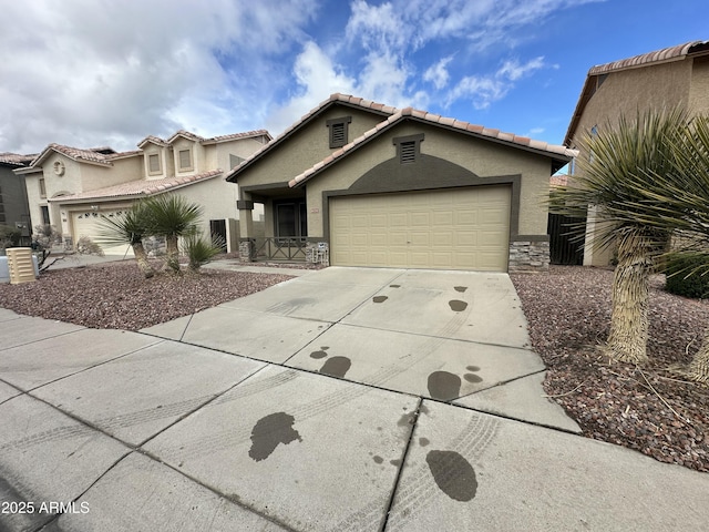 view of front of house with stucco siding, a garage, stone siding, driveway, and a tiled roof