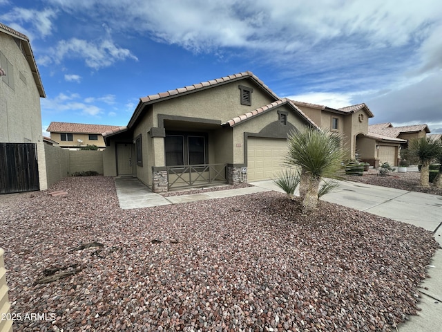 view of front facade featuring a garage, driveway, stone siding, fence, and stucco siding