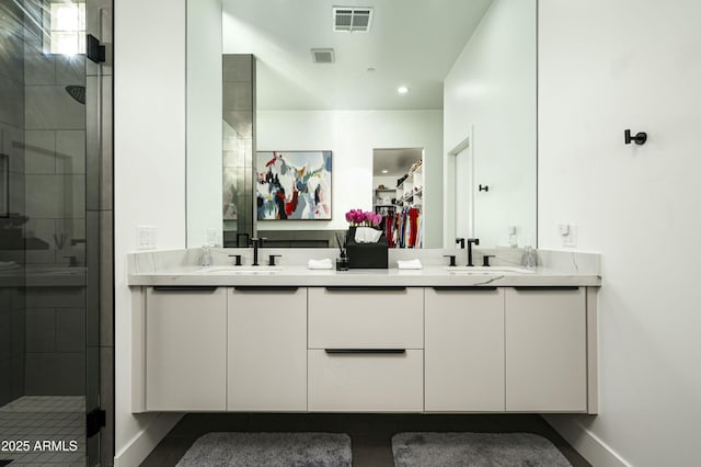 full bathroom with a stall shower, a sink, and visible vents