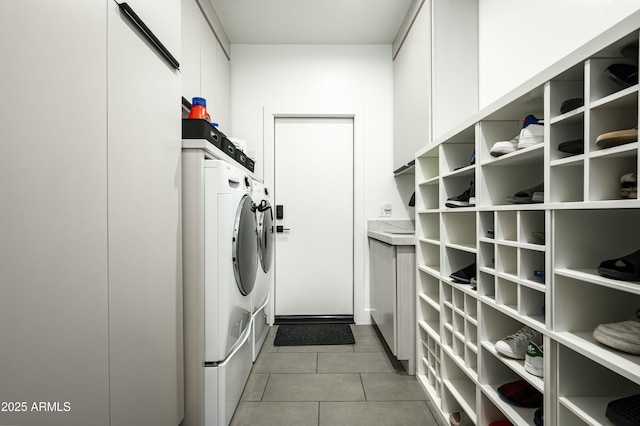 laundry area featuring laundry area, light tile patterned floors, and washer and clothes dryer