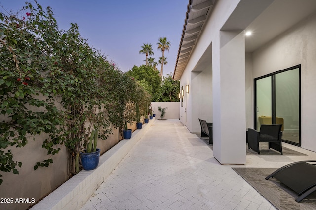 patio terrace at dusk featuring fence