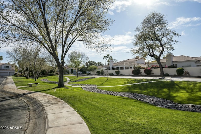 view of community with a yard and fence