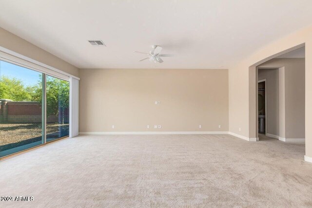 unfurnished room featuring baseboards, a ceiling fan, visible vents, and light colored carpet