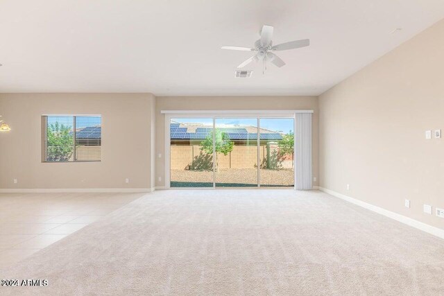 carpeted spare room featuring ceiling fan