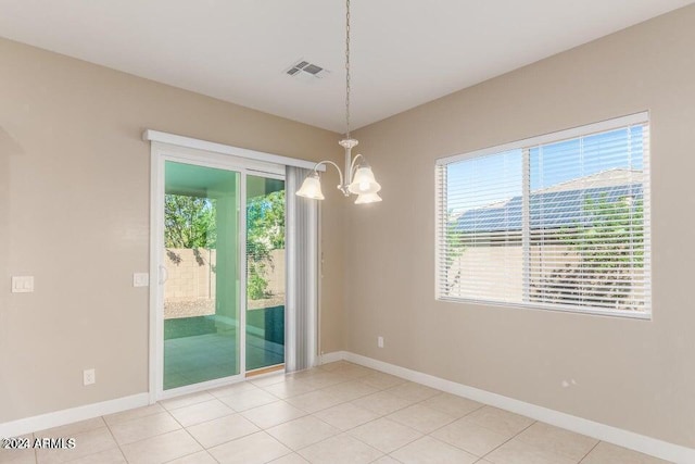 empty room with plenty of natural light, visible vents, a chandelier, and baseboards