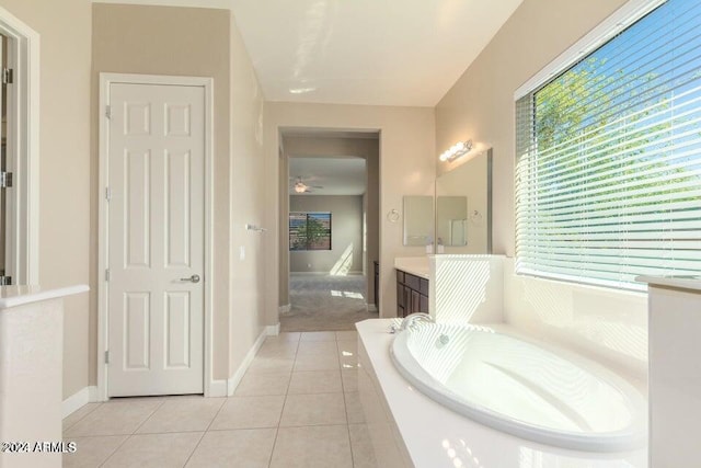 bathroom featuring tiled tub, vanity, ceiling fan, and tile patterned flooring