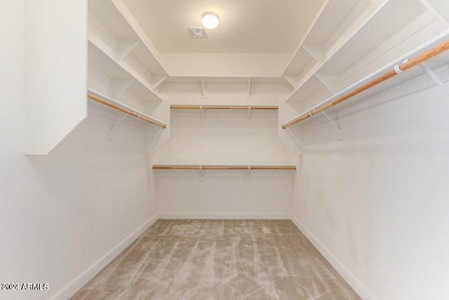 walk in closet with light carpet and visible vents