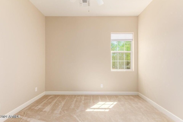 spare room featuring light carpet, baseboards, visible vents, and ceiling fan