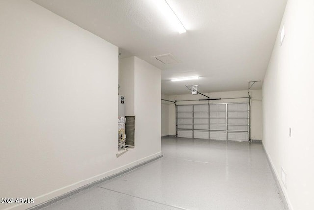 garage featuring a garage door opener and baseboards