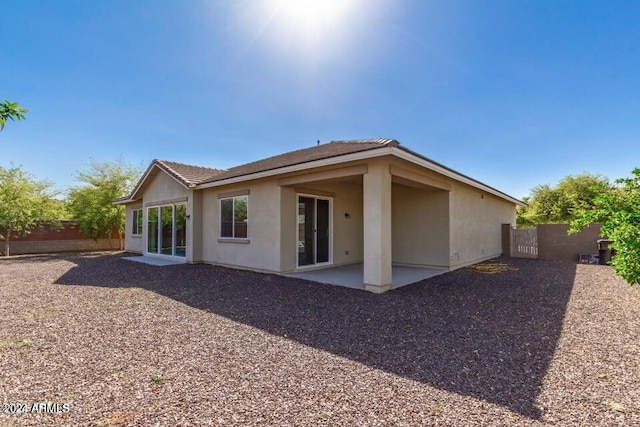 back of property featuring stucco siding, a fenced backyard, and a patio