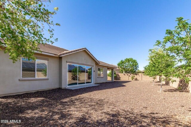 back of house featuring a fenced backyard and stucco siding