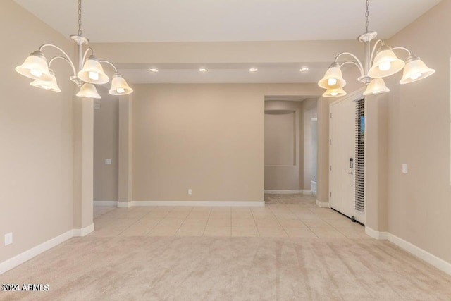 spare room featuring light tile patterned floors, baseboards, and an inviting chandelier