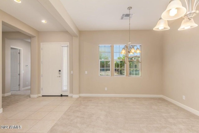 entrance foyer with a chandelier and light carpet