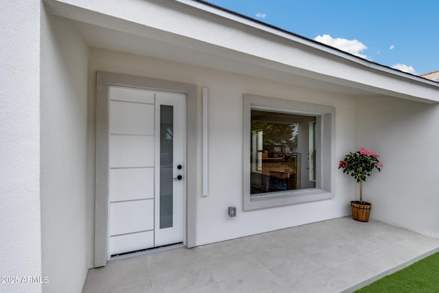 property entrance with stucco siding