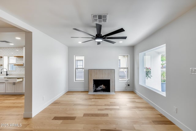 unfurnished living room with light wood-type flooring, a ceiling fan, visible vents, recessed lighting, and baseboards
